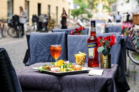 Besøg den hyggelige Restaurant Eros, som ligger helt centralt i København på Gråbrødre Torv. Her bliver du forkælet med en dejlig sommerplatte til frokost. Platten ledsages af den klassiske sommerdrink Aperol Spritz.